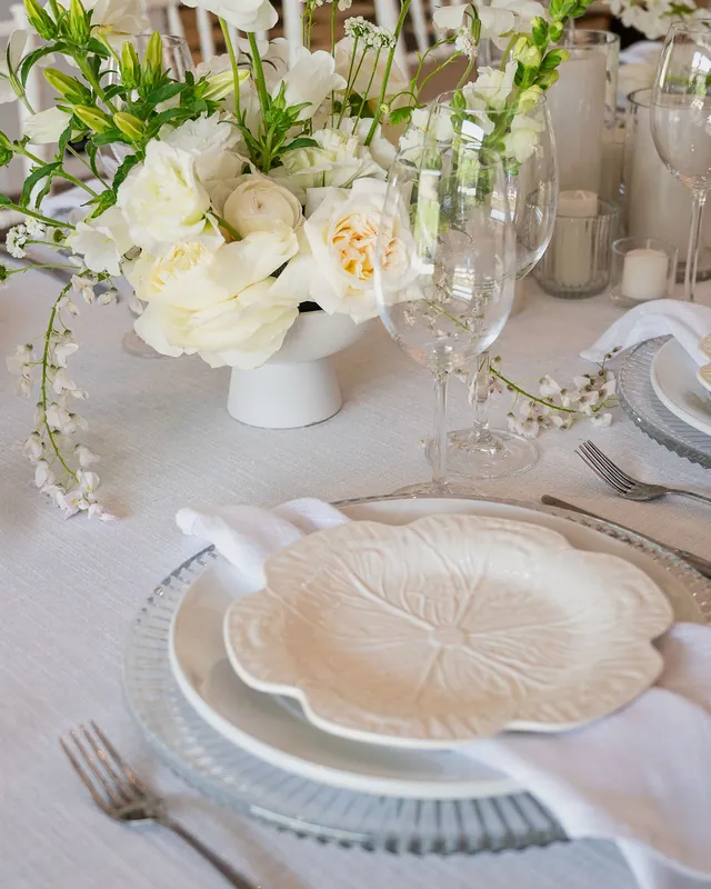 Neutral tablescape with white floral styling and layered place settings