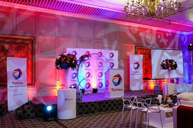 Branded Total presentation stage styled with vivid event lighting