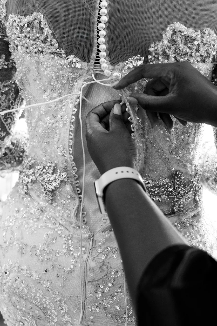 Hands fastening an embellished dress