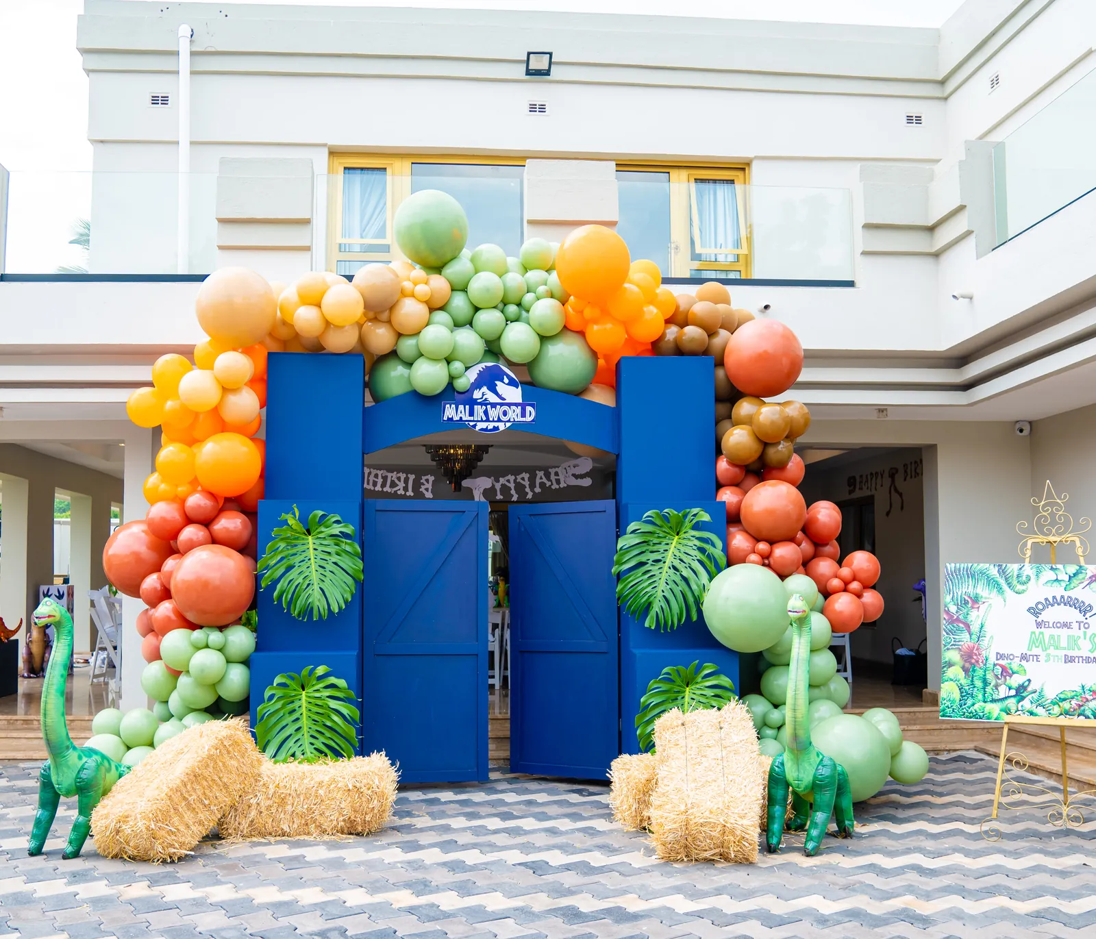 Dinosaur fifth-birthday entrance framed by colourful balloons