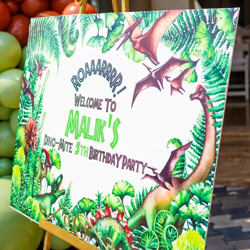 Personalised dinosaur welcome sign surrounded by balloons