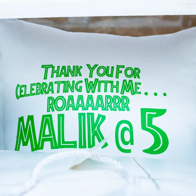 Personalised dinosaur birthday cushion celebrating Malik at five