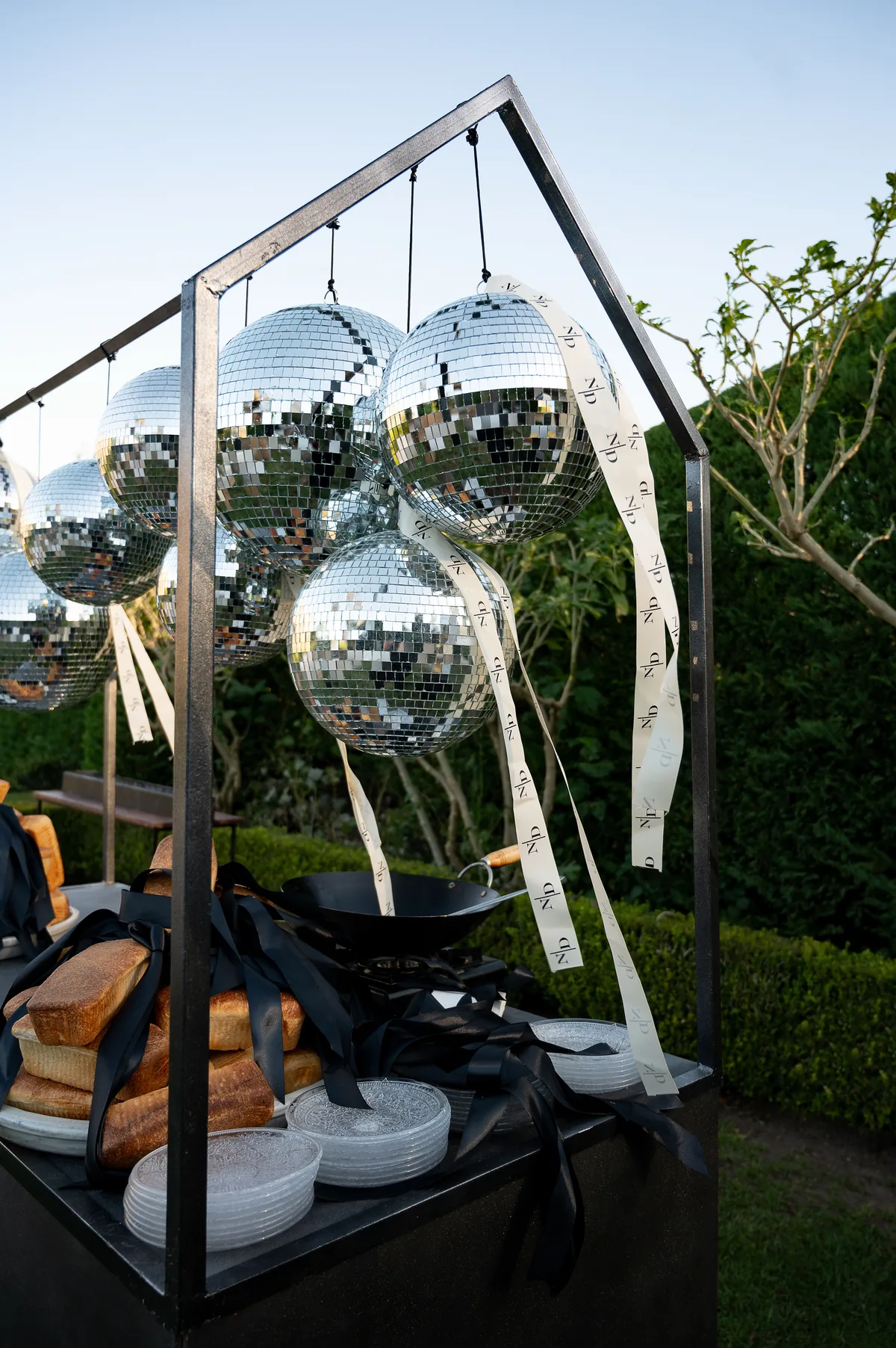 Reflective hanging installation among the garden seating